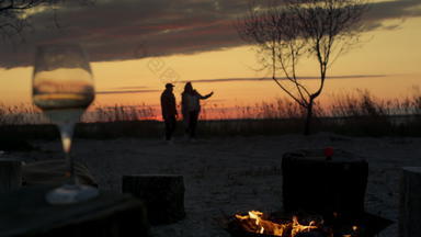 浪漫的夫妇走日落海滩野营篝火海景观